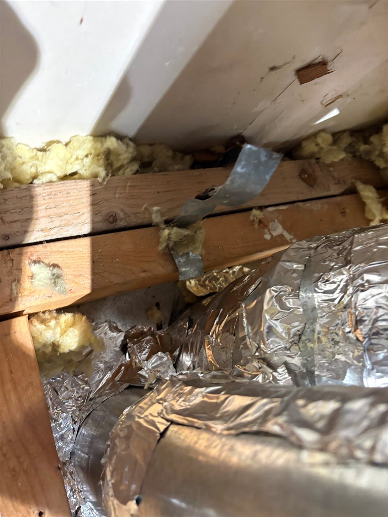 Open bathroom ceiling showing duct and insulation