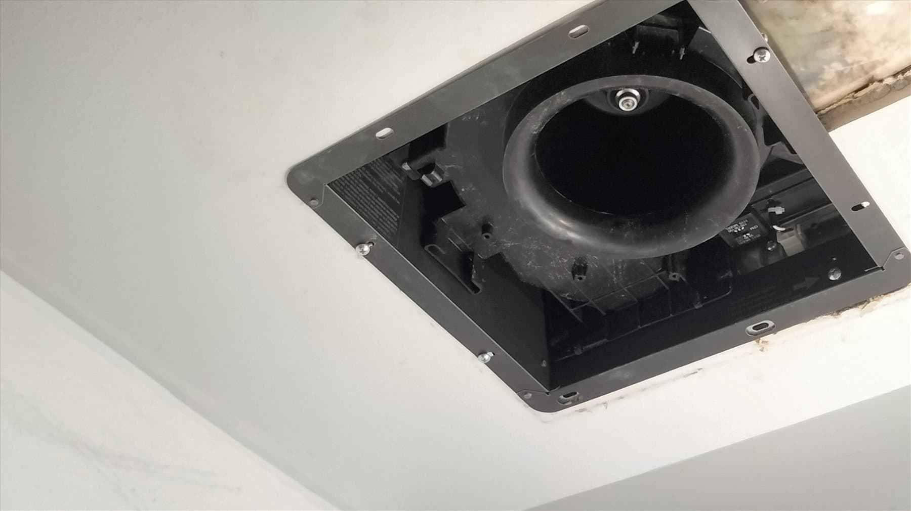 New bathroom fan housing connected above the ceiling