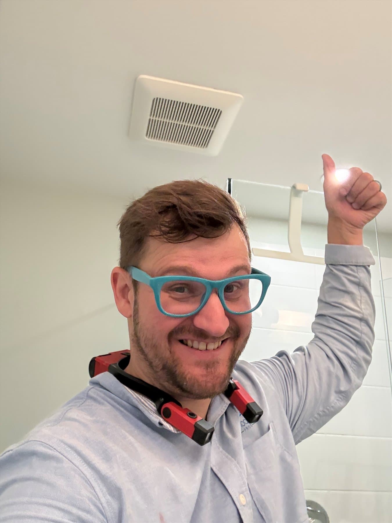 Bathroom Fan Pros specialist beside a completed bathroom fan replacement in Langley
