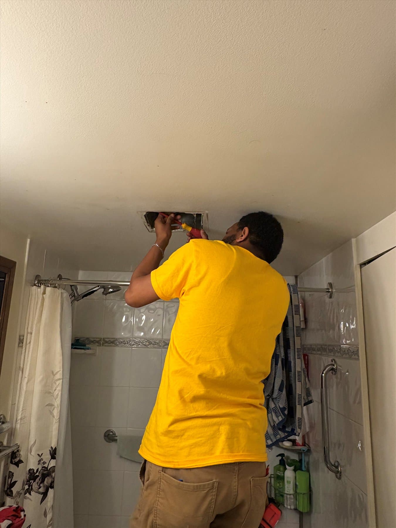 Second installer helping with the bathroom fan replacement